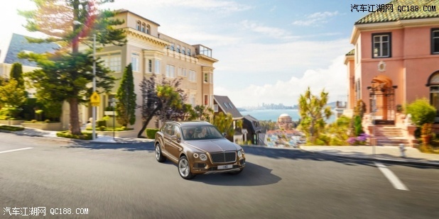 Bronze Bentayga turning a corner with a view overlooking houses and a city | Bentley Motors